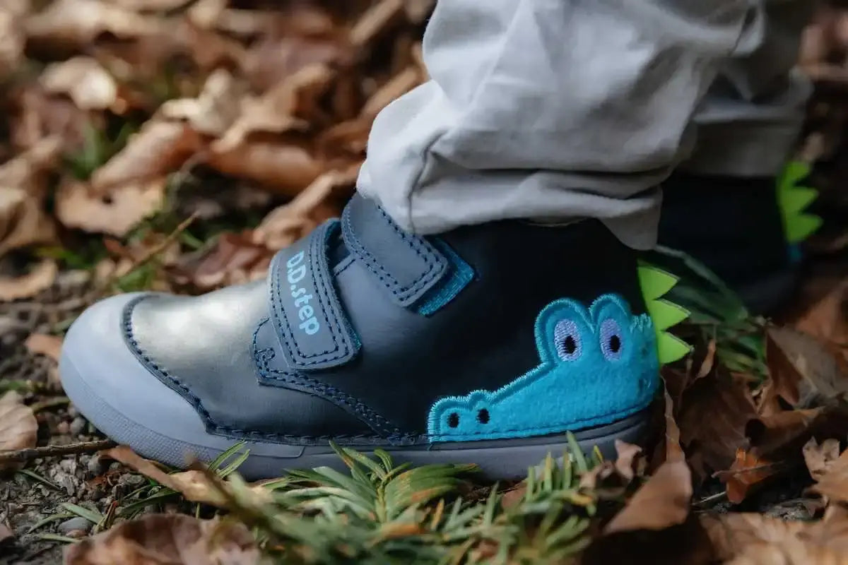 Kinder Lauflernschuhe aus Leder mit buntem Design und Klettverschluss auf einem Waldweg